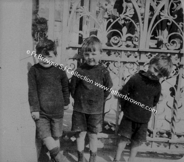 THREE BOYS OUTSIDE CHURCH GATE